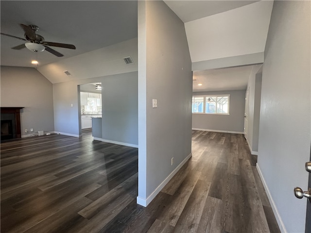 unfurnished living room with dark hardwood / wood-style floors, vaulted ceiling, and ceiling fan