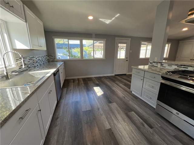 kitchen with white cabinets, decorative backsplash, stainless steel appliances, and sink