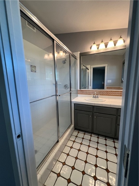 bathroom featuring vanity and a shower with door