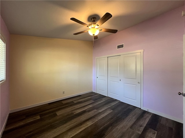 unfurnished bedroom with ceiling fan, a closet, and dark wood-type flooring