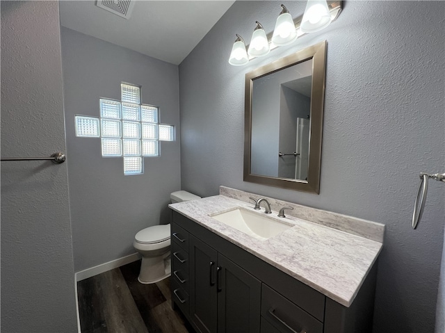 bathroom with hardwood / wood-style flooring, vanity, and toilet