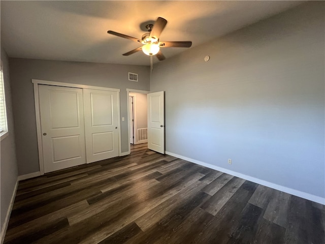 unfurnished bedroom featuring lofted ceiling, ceiling fan, a closet, and dark hardwood / wood-style floors