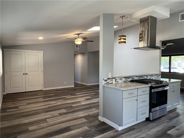 kitchen with hanging light fixtures, stainless steel gas range, island range hood, light stone counters, and white cabinetry