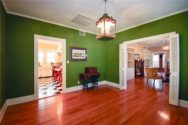 interior space with hardwood / wood-style flooring, a chandelier, and ornamental molding