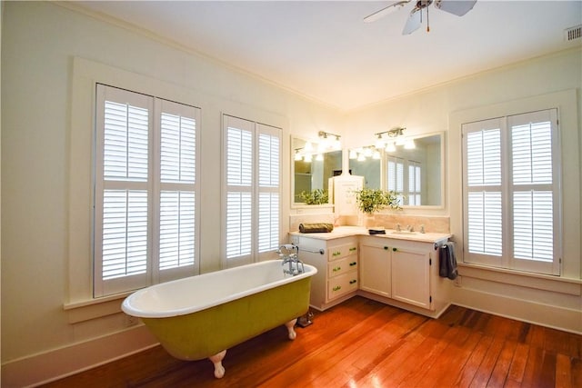 203 S Bowie St, Sinton, TX 78387 - full bath featuring hardwood / wood-style flooring, crown molding, a soaking tub, ceiling fan, and vanity