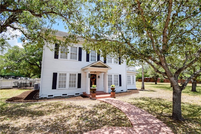 colonial home featuring central AC and a front lawn