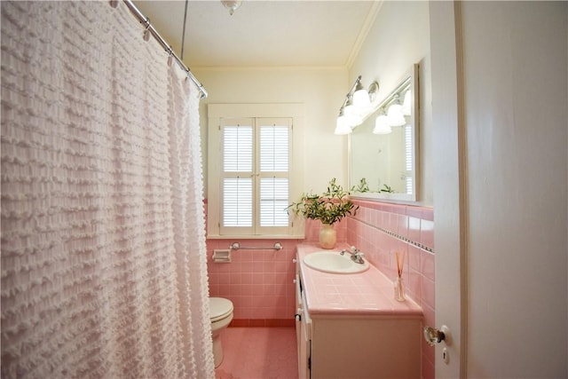203 S Bowie St, Sinton, TX 78387 - full bath with toilet, tile walls, vanity, ornamental molding, and a wainscoted wall