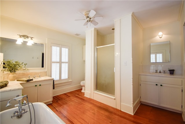 full bathroom featuring tasteful backsplash, ceiling fan, wood-type flooring, vanity, and crown molding