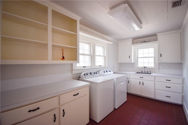 washroom with sink, cabinets, washing machine and clothes dryer, and ornamental molding