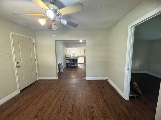 foyer featuring dark hardwood / wood-style flooring, a textured ceiling, and ceiling fan