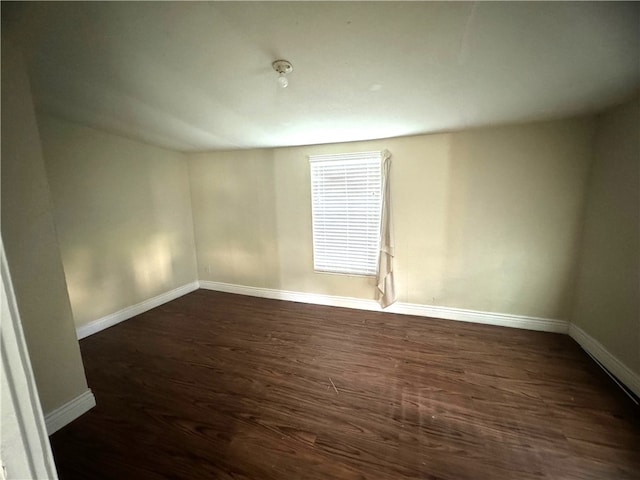 empty room with dark hardwood / wood-style flooring