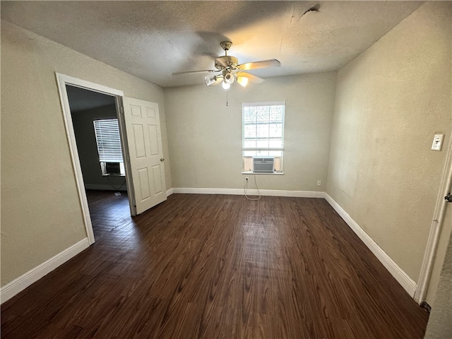 spare room featuring a textured ceiling, dark hardwood / wood-style flooring, cooling unit, and ceiling fan