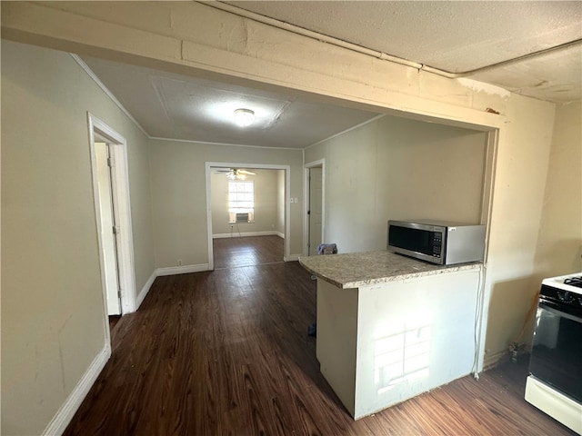 kitchen featuring a textured ceiling, white gas range, dark wood-type flooring, and ceiling fan