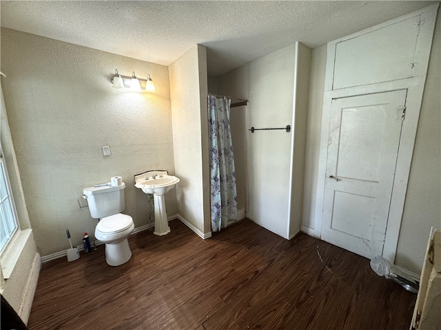 bathroom with walk in shower, hardwood / wood-style flooring, sink, a textured ceiling, and toilet