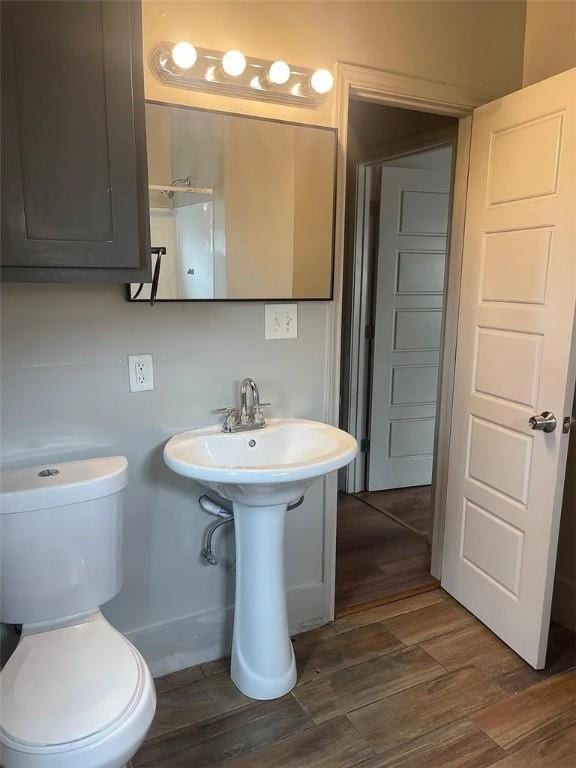 2129 16th St, Corpus Christi, TX 78404 - half bathroom with a sink, toilet, and wood finished floors