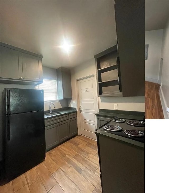 2129 16th St, Corpus Christi, TX 78404 - kitchen featuring freestanding refrigerator, dark countertops, wood finish floors, and a sink