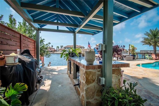 view of patio with grilling area, a water view, and a gazebo