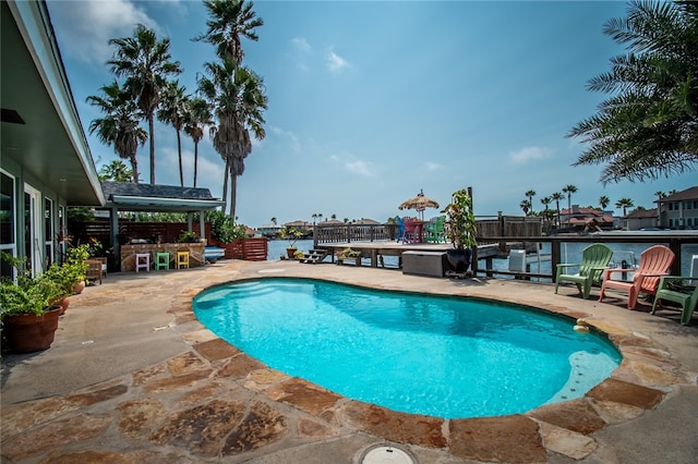 view of pool with a patio and a water view