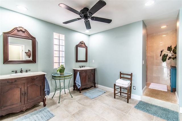 bathroom with tile patterned flooring, tiled shower, ceiling fan, and vanity