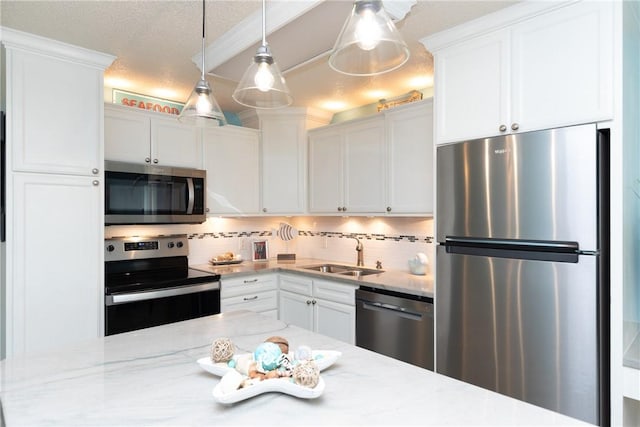 kitchen with sink, backsplash, decorative light fixtures, white cabinets, and appliances with stainless steel finishes