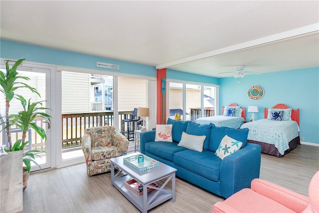 bedroom with ceiling fan, access to exterior, light wood-type flooring, and a textured ceiling