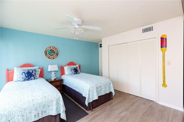 bedroom featuring light hardwood / wood-style flooring, a closet, and ceiling fan