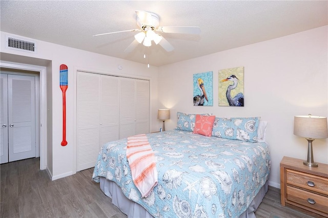 bedroom featuring ceiling fan, a closet, hardwood / wood-style floors, and a textured ceiling