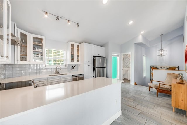 800 Beach Access Road 1a 804, Port Aransas, TX 78373 - kitchen featuring appliances with stainless steel finishes, a sink, tasteful backsplash, light countertops, and a peninsula