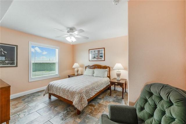 800 Beach Access Road 1a 804, Port Aransas, TX 78373 - bedroom featuring baseboards, stone finish floors, and a ceiling fan
