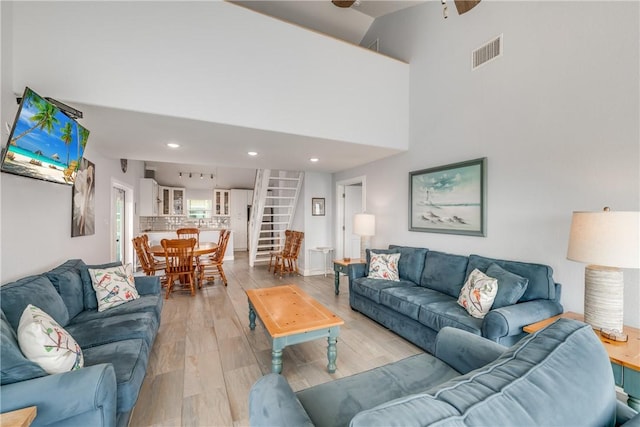 800 Beach Access Road 1a 804, Port Aransas, TX 78373 - living room with stairway, a ceiling fan, a high ceiling, recessed lighting, and light wood-style floors