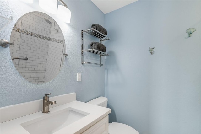 800 Beach Access Road 1a 804, Port Aransas, TX 78373 - full bathroom with toilet, tiled shower, vanity, and a textured wall