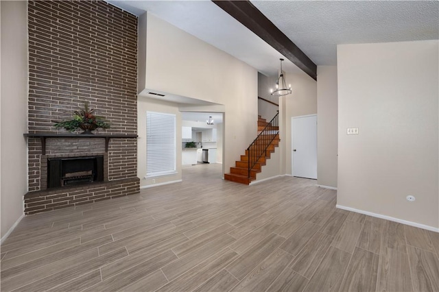 unfurnished living room featuring stairs, a brick fireplace, visible vents, and wood tiled floor