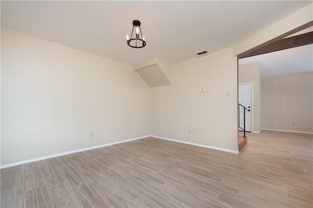 unfurnished room featuring wood finish floors, visible vents, and baseboards