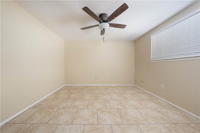 spare room featuring a ceiling fan, baseboards, and light tile patterned floors