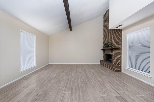 unfurnished living room featuring baseboards, visible vents, vaulted ceiling with beams, light wood-style floors, and a fireplace