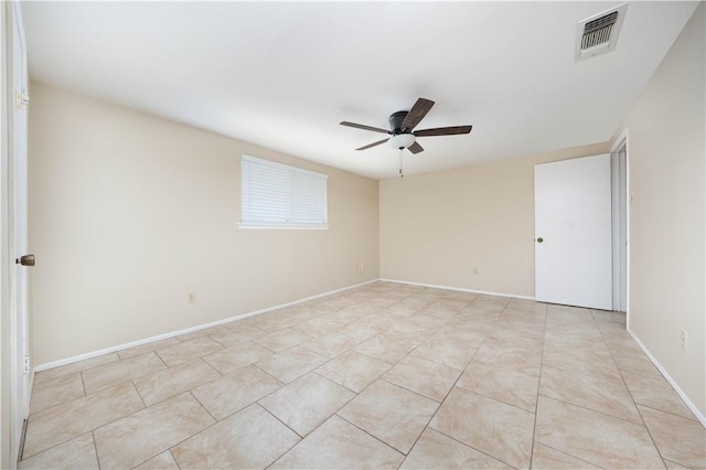 empty room featuring baseboards, visible vents, a ceiling fan, and light tile patterned flooring