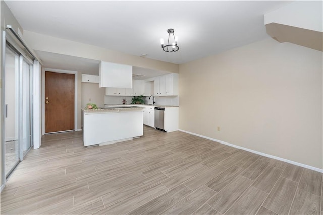 kitchen featuring wood tiled floor, white cabinets, stainless steel dishwasher, and light countertops