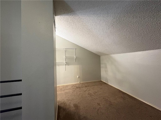 bonus room featuring vaulted ceiling, carpet floors, and a textured ceiling