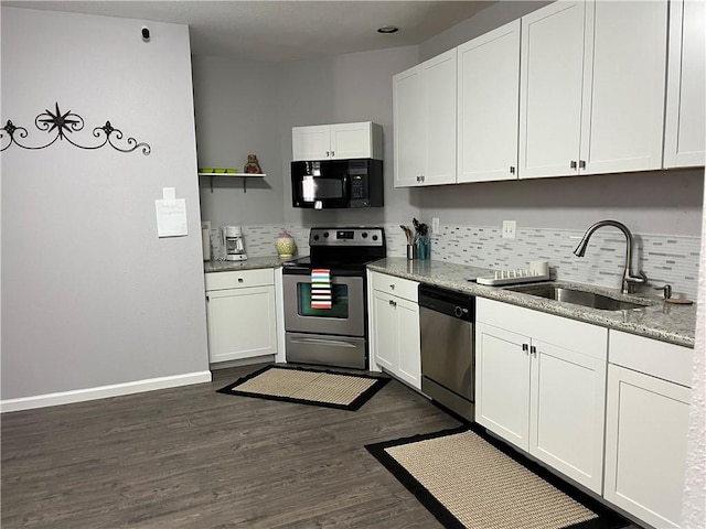 kitchen with light stone countertops, white cabinetry, sink, and appliances with stainless steel finishes