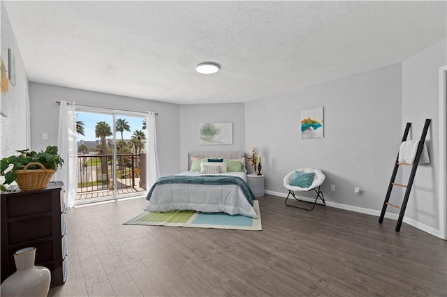 bedroom featuring dark hardwood / wood-style flooring, a textured ceiling, and access to outside