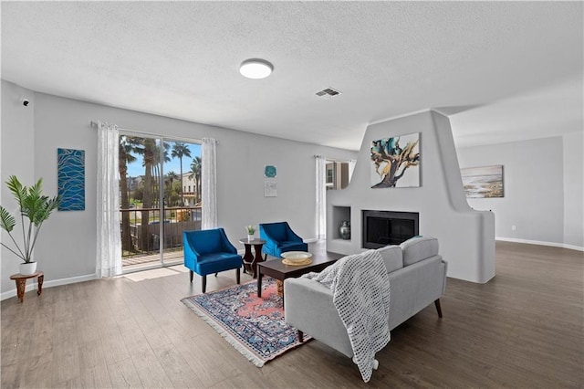 living room featuring a textured ceiling and dark wood-type flooring