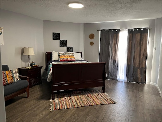 bedroom with dark hardwood / wood-style flooring and a textured ceiling