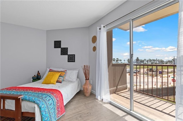 bedroom featuring access to exterior and wood-type flooring