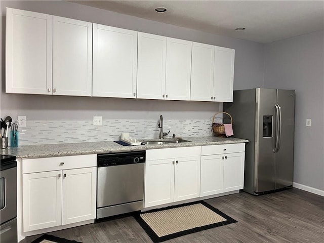 kitchen featuring sink, dark hardwood / wood-style floors, light stone countertops, appliances with stainless steel finishes, and white cabinetry