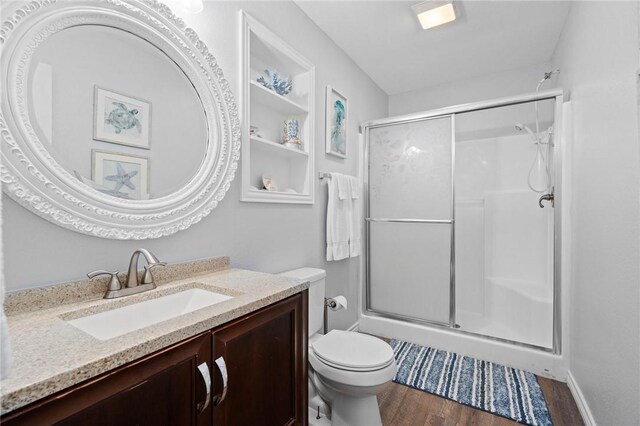 2001 S Doughty St, Rockport, TX 78382 - bathroom with a shower stall, wood finished floors, toilet, and vanity