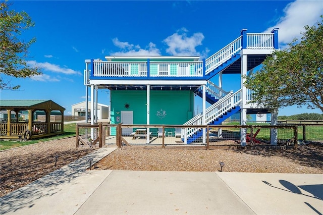 2001 S Doughty St, Rockport, TX 78382 - back of property featuring stairs, a gazebo, fence, and a patio area