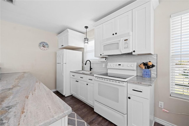2001 S Doughty St, Rockport, TX 78382 - kitchen with white appliances, backsplash, dark wood finished floors, a sink, and white cabinets
