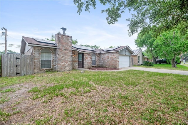 ranch-style home with a front lawn, a garage, and solar panels