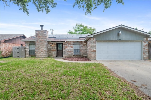 ranch-style home with a front lawn, a garage, and solar panels