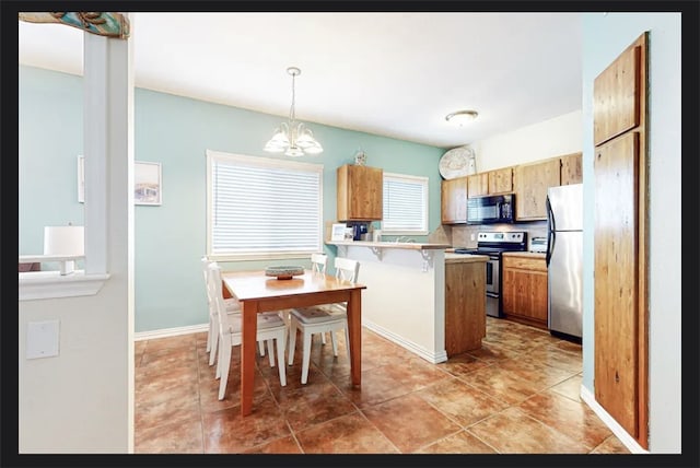 kitchen featuring appliances with stainless steel finishes, a notable chandelier, hanging light fixtures, a breakfast bar area, and kitchen peninsula